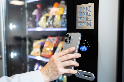 Man making contactless payment at vending machine